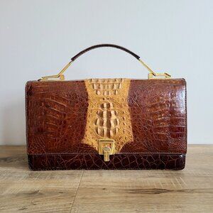 Vintage crocodile leather bag with gold metal details. Retro fashion accessories
